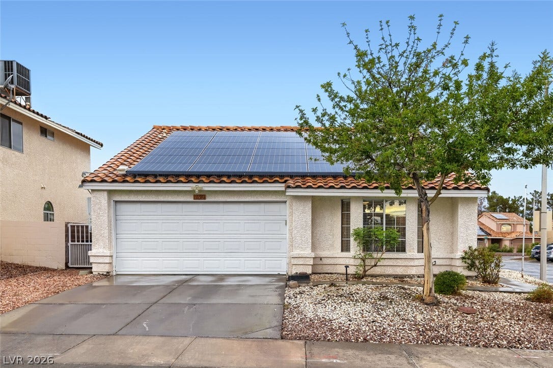 749 Tenderfoot Circle, Henderson, NV 89014 Solar panels crown this classic stucco home featuring a tile roof and clean driveway.