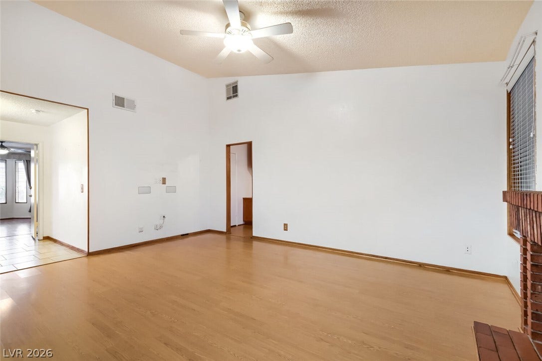 749 Tenderfoot Circle, Henderson, NV 89014 High vaulted ceilings and rich wood-look flooring define this comfortable living space.