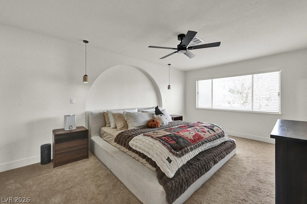 314 Encima Court, Henderson, NV 89014 A striking arched alcove creates a unique focal point in this carpeted bedroom.