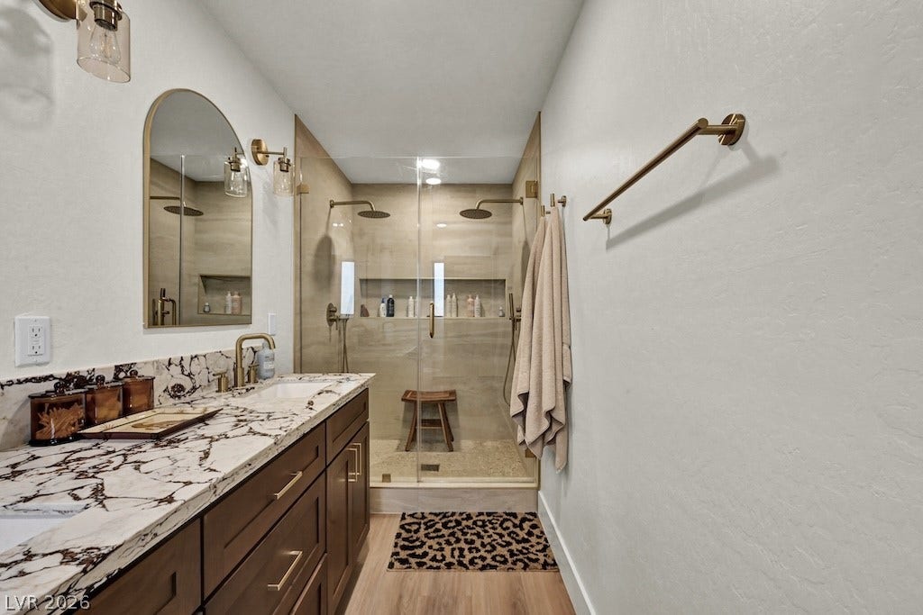 314 Encima Court, Henderson, NV 89014 A modern double vanity features elegant stone countertops alongside a spacious walk-in glass shower.