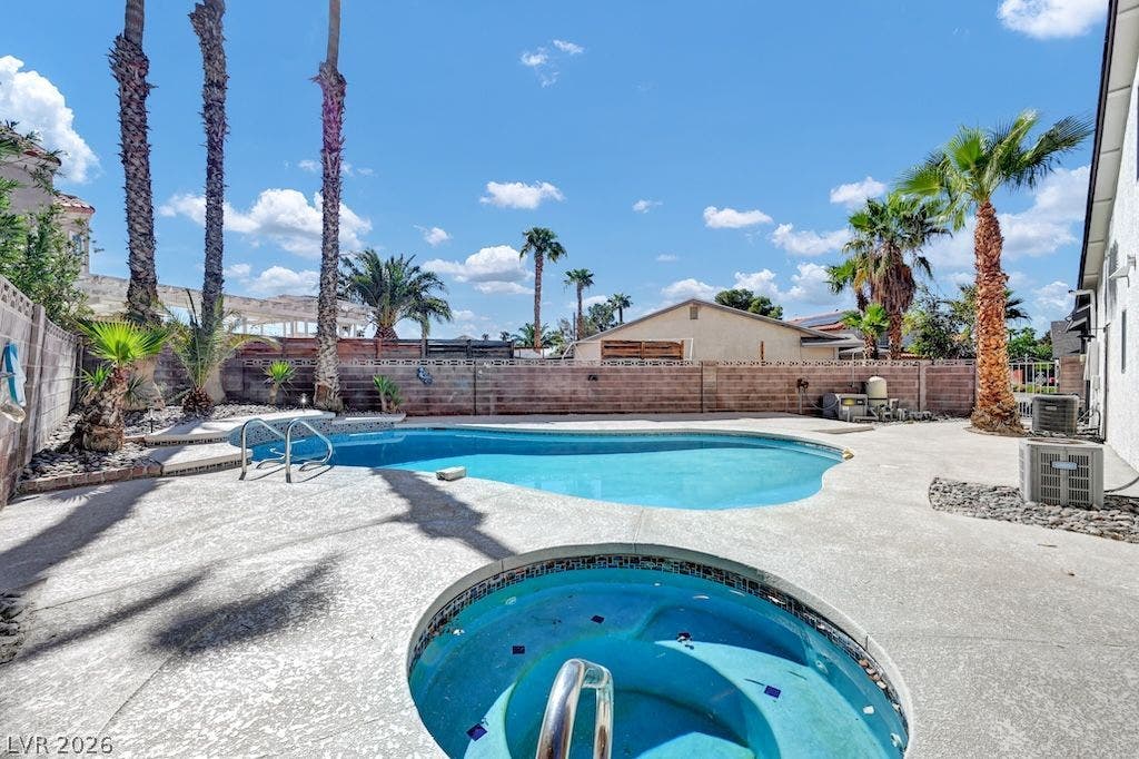 314 Encima Court, Henderson, NV 89014 Palm trees frame a sparkling inground pool and spa surrounded by spacious concrete decking.