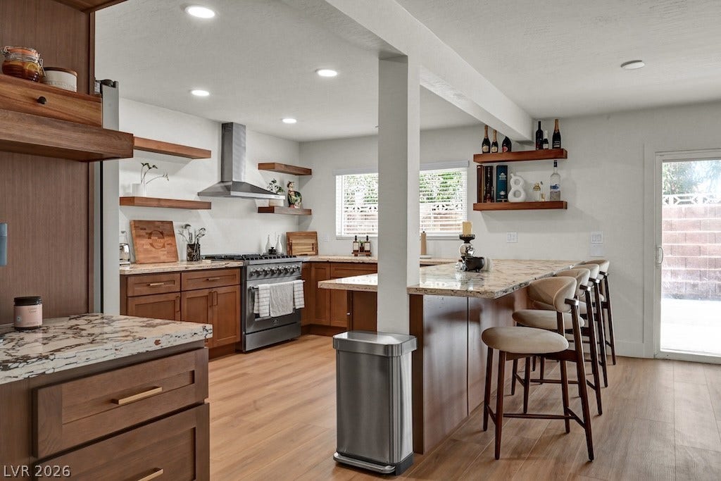 314 Encima Court, Henderson, NV 89014 Rich wood cabinetry and expansive granite countertops define this modern, open-concept kitchen space.