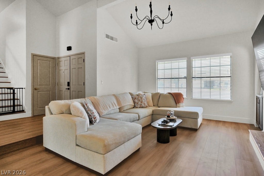 314 Encima Court, Henderson, NV 89014 High vaulted ceilings and wood-style flooring elevate this comfortable central gathering space.