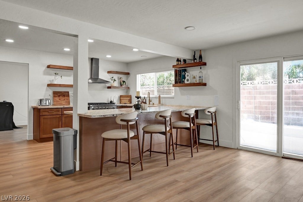 314 Encima Court, Henderson, NV 89014 Warm wood flooring and natural stone countertops anchor this inviting modern kitchen space.
