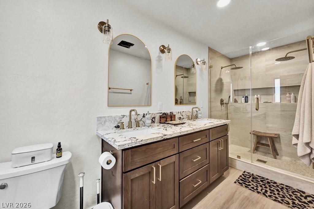 314 Encima Court, Henderson, NV 89014 Fine stone countertops and a spacious glass-enclosed shower elevate this modern bathroom design.
