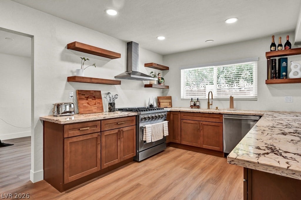 314 Encima Court, Henderson, NV 89014 Rich wood cabinetry and dramatic stone countertops define this well-appointed culinary workspace.