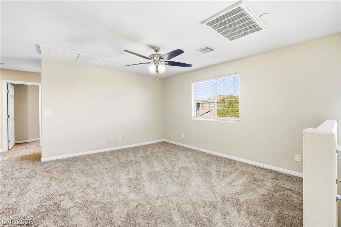 2221 Mundare Drive, Henderson, NV 89002 Plush carpeting and a wide window define this versatile upper-level loft space.