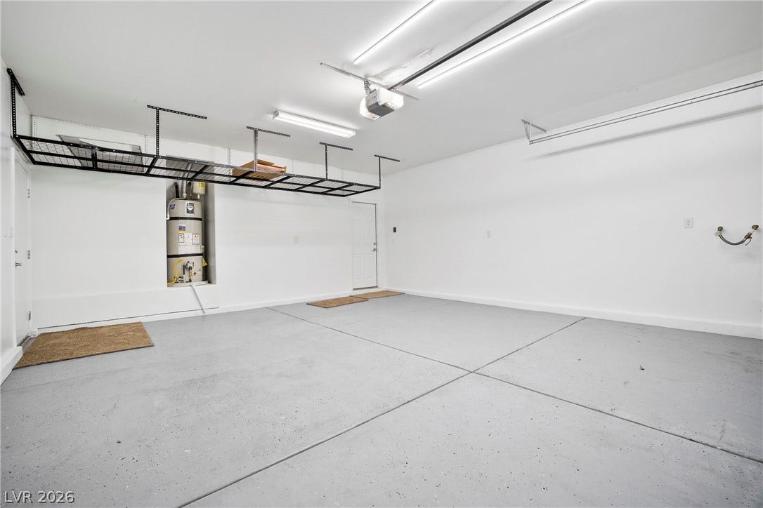 2221 Mundare Drive, Henderson, NV 89002 A spacious garage includes overhead storage racks and concrete flooring.