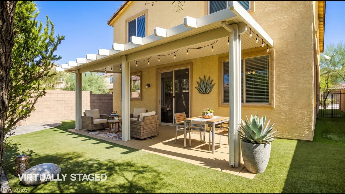 2221 Mundare Drive, Henderson, NV 89002 An inviting covered patio features integrated shade structures alongside a manicured lawn area.