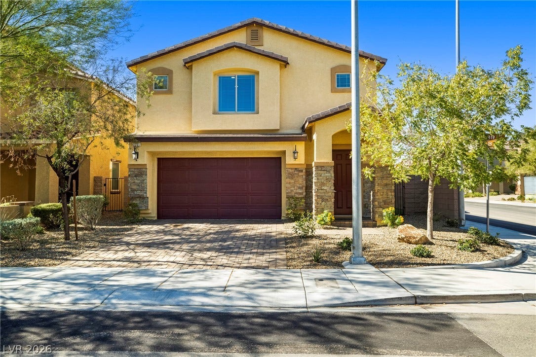 2221 Mundare Drive, Henderson, NV 89002 Stone accents and a paved driveway complement this multi-level home with an attached garage.
