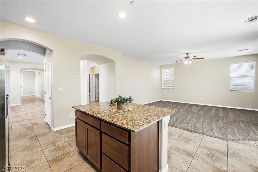 2221 Mundare Drive, Henderson, NV 89002 Spacious tile flooring flows from the kitchen island into an adjacent carpeted living area.