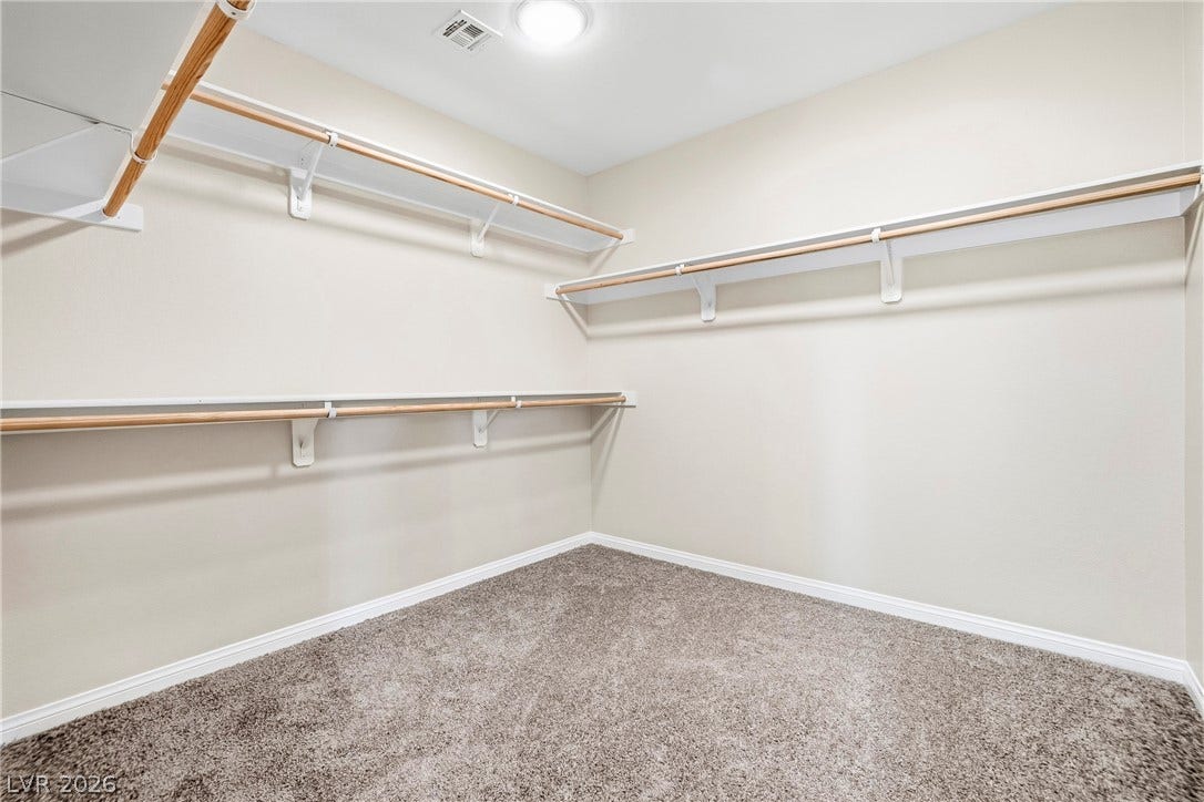 2221 Mundare Drive, Henderson, NV 89002 Generous hanging rods and open shelving maximize storage space in this carpeted walk-in closet.