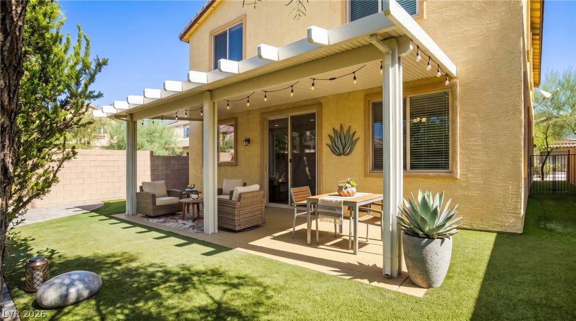 2221 Mundare Drive, Henderson, NV 89002 An inviting backyard patio features a spacious covered pergola overlooking a manicured lawn.