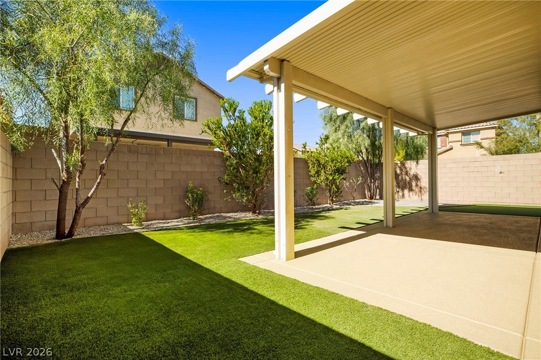 2221 Mundare Drive, Henderson, NV 89002 A spacious covered patio overlooks the manicured green lawn and secure block wall fencing.