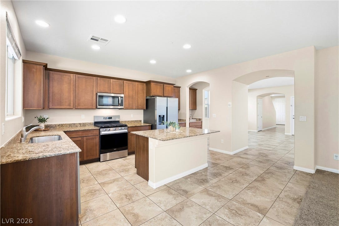 2221 Mundare Drive, Henderson, NV 89002 An open-concept layout connects the kitchen, featuring granite countertops and tile flooring, to adjacent spaces.