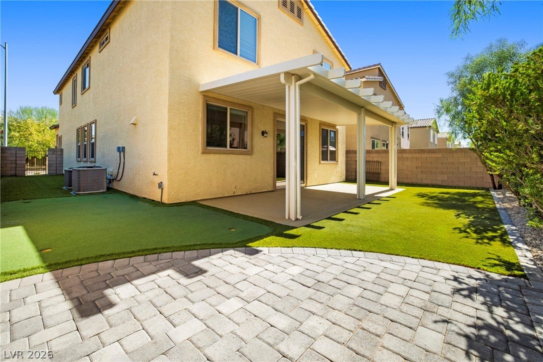 2221 Mundare Drive, Henderson, NV 89002 A spacious covered patio overlooks a manicured green lawn and neat block paving.