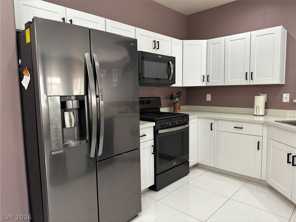 6089 Mustang Breeze Trail, #102, Henderson, NV 89011 Crisp white cabinetry pairs with large-format tile flooring in this functional culinary space.