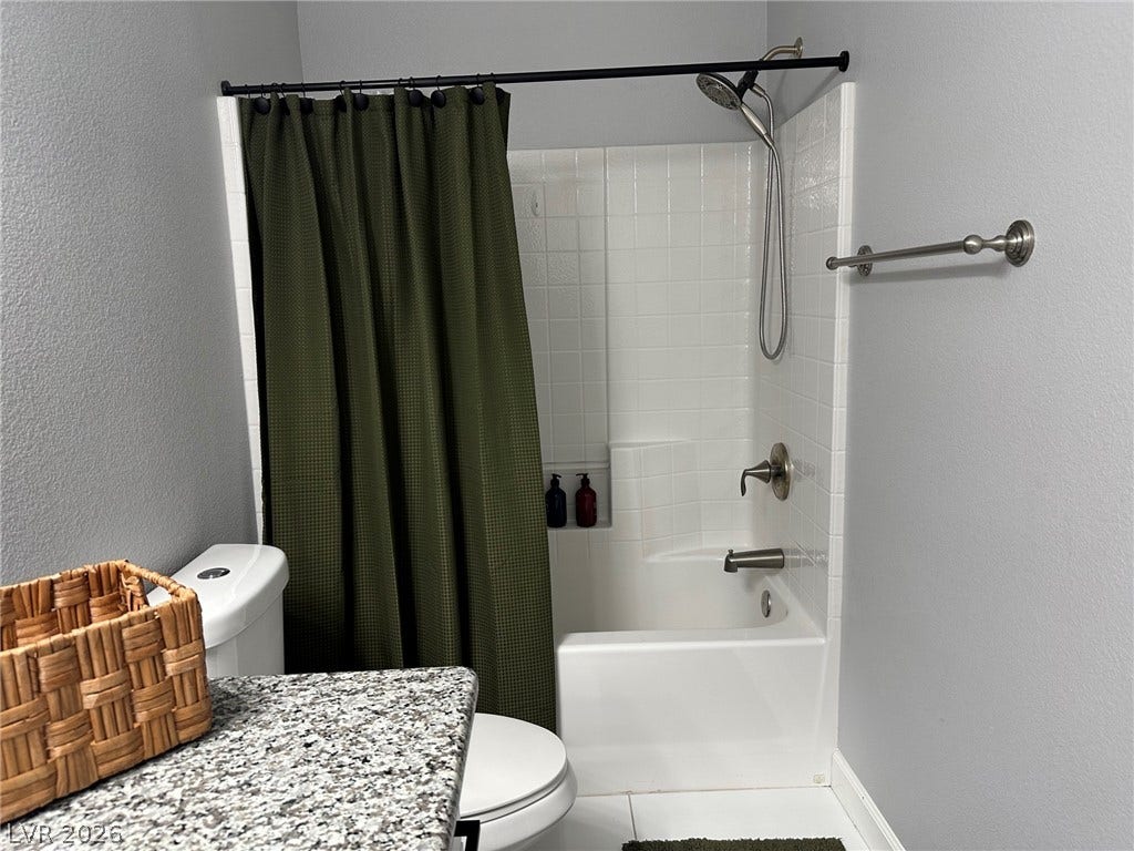 6089 Mustang Breeze Trail, #102, Henderson, NV 89011 White wall tiles enclose a classic bathtub and shower combination.