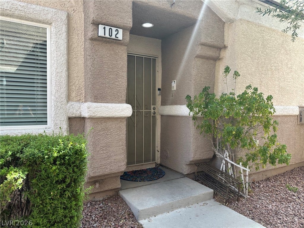 6089 Mustang Breeze Trail, #102, Henderson, NV 89011 An inviting recessed entryway is framed by textured stucco walls and classic architectural details.