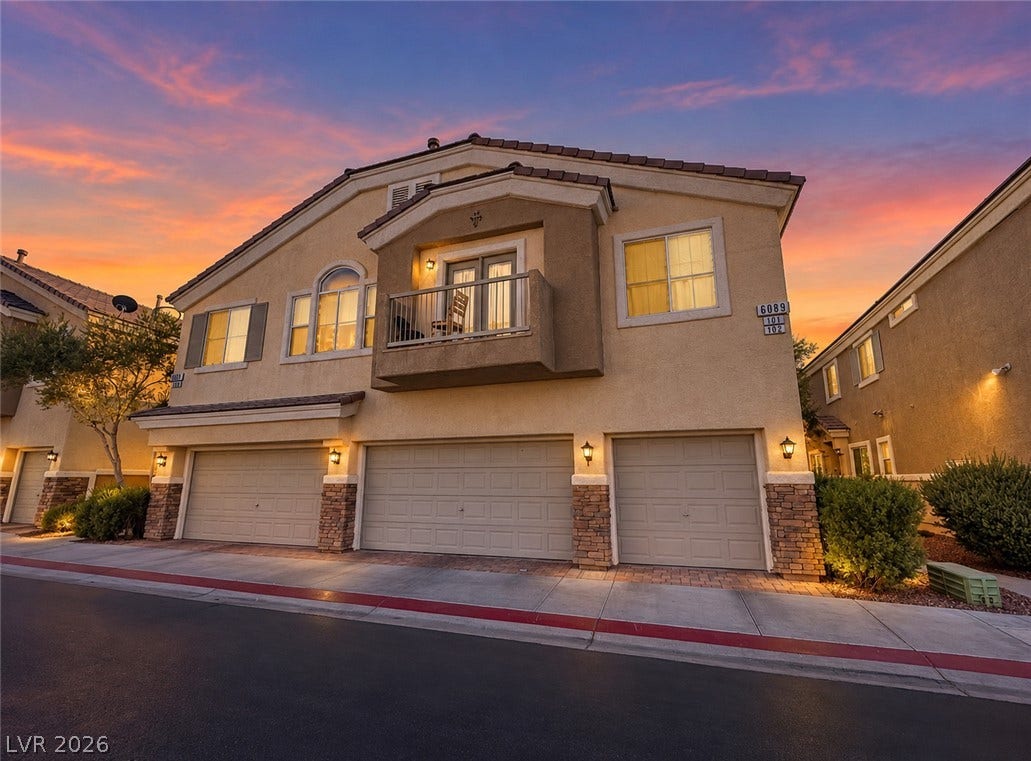 6089 Mustang Breeze Trail, #102, Henderson, NV 89011 Stucco cladding, stone accents, and a private balcony define this multi-level facade.