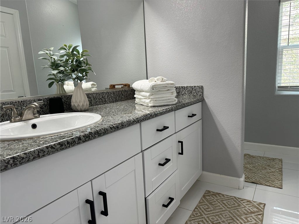 6089 Mustang Breeze Trail, #102, Henderson, NV 89011 A classic stone-topped vanity anchors this well-appointed washroom space.