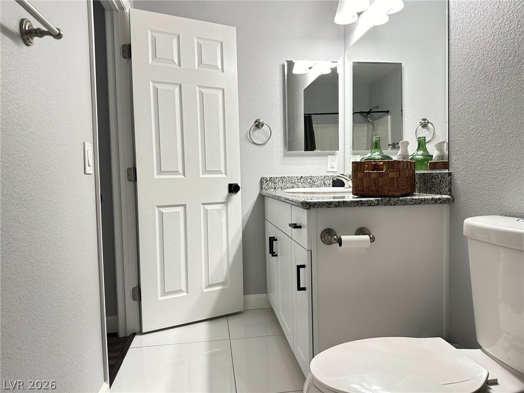 6089 Mustang Breeze Trail, #102, Henderson, NV 89011 Polished tile flooring complements the stone vanity top in this updated bathroom.