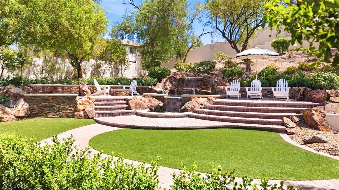 8 Pine Hollow Drive, Henderson, NV 89052 Tiered stone patios and a cascading waterfall define this backyard retreat