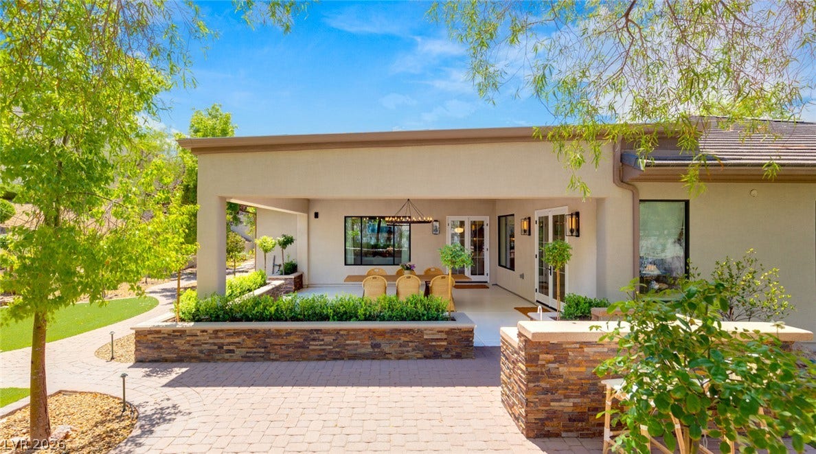 8 Pine Hollow Drive, Henderson, NV 89052 A spacious covered patio opens onto a paved terrace lined with stacked-stone planter boxes.