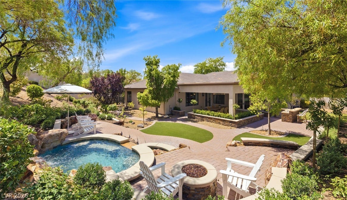 8 Pine Hollow Drive, Henderson, NV 89052 Lush, resort-style landscaping, a two-tiered spa waterfall, and a fire pit elevate the outdoor living experience.