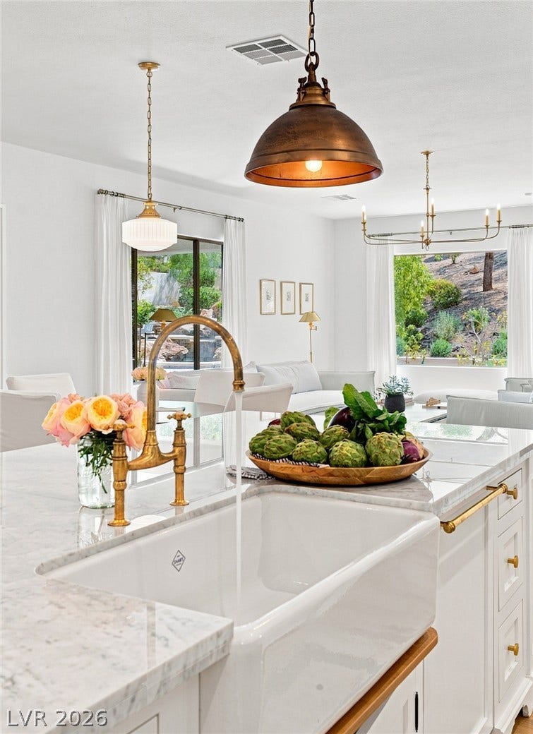 8 Pine Hollow Drive, Henderson, NV 89052 An open kitchen island with marble counters opens onto a bright family room.