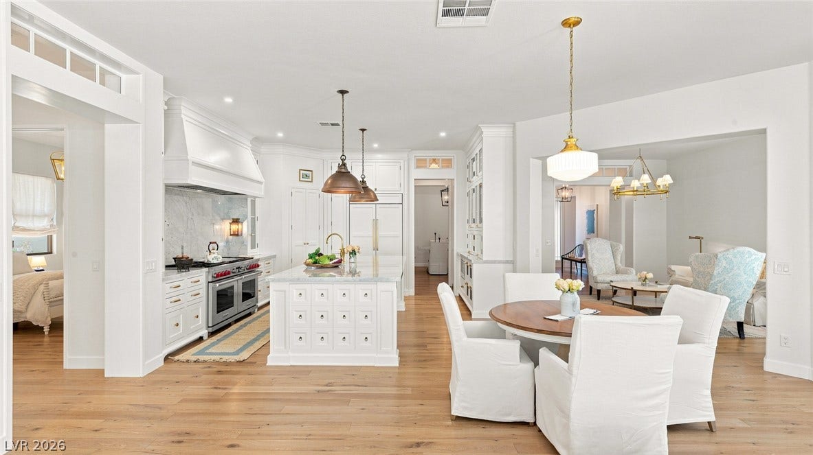 8 Pine Hollow Drive, Henderson, NV 89052 Hardwood floors and crisp white cabinetry define this airy kitchen and integrated casual dining space.