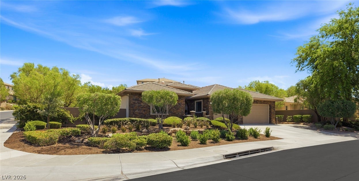 8 Pine Hollow Drive, Henderson, NV 89052 Stone accents and manicured desert landscaping frame this single-story home's exterior.
