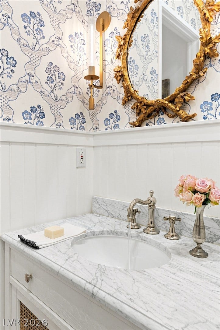 8 Pine Hollow Drive, Henderson, NV 89052 Elegant marble vanity surfaces complement classic wallpaper in this refined powder room.