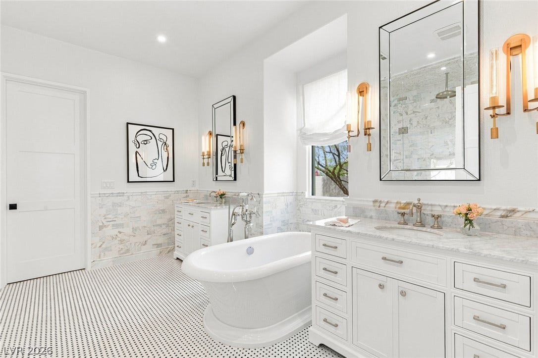 8 Pine Hollow Drive, Henderson, NV 89052 Calacatta marble and a freestanding tub define this elegant primary bathroom space.