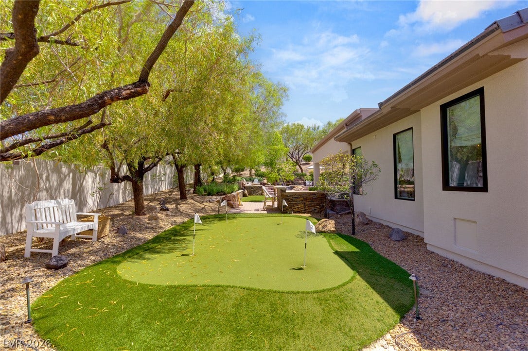 8 Pine Hollow Drive, Henderson, NV 89052 Mature trees provide shade over a private backyard putting green beside the home.