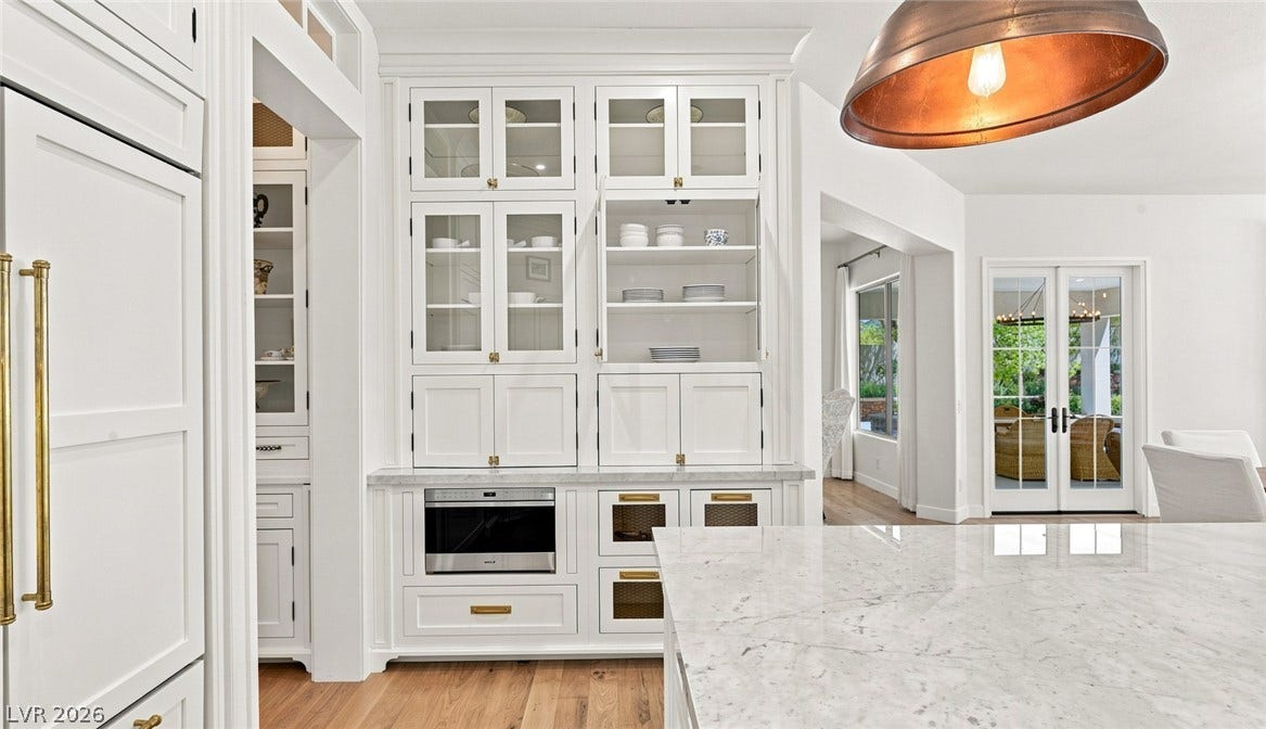 8 Pine Hollow Drive, Henderson, NV 89052 Custom cabinetry and polished marble countertops elevate this airy gourmet kitchen.