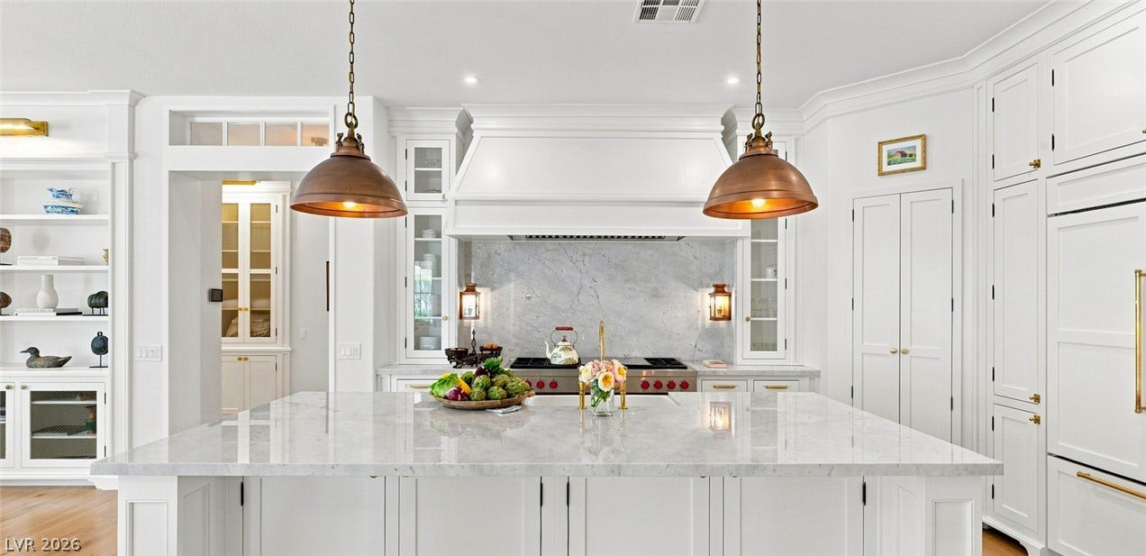8 Pine Hollow Drive, Henderson, NV 89052 Carrara marble countertops and custom cabinetry define this high-end kitchen workspace.