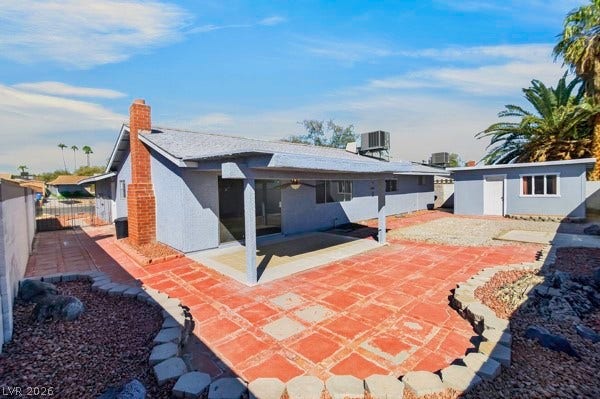 4284 Annie Oakley Drive, Las Vegas, NV 89121 An expansive backyard patio setup features a covered concrete pad and classic brick pavers.