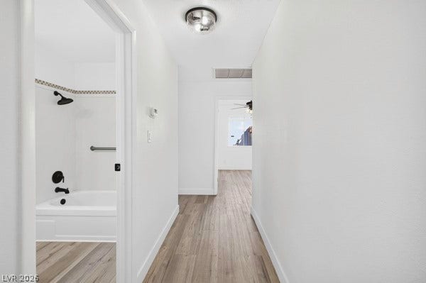 4284 Annie Oakley Drive, Las Vegas, NV 89121 Smooth wood flooring connects the bright hallway to an adjacent bathroom and bedroom.