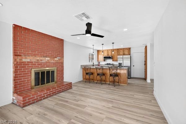 4284 Annie Oakley Drive, Las Vegas, NV 89121 An open floorplan connects the living space and its brick fireplace to the kitchen.