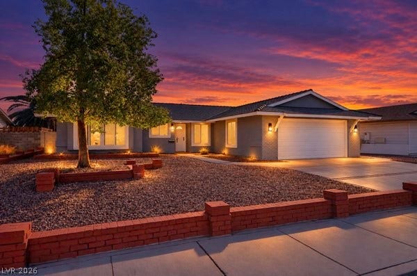 4284 Annie Oakley Drive, Las Vegas, NV 89121 Manicured desert landscaping and a low brick wall frame this welcoming single-level residence.
