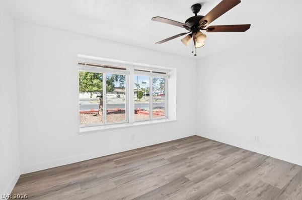 4284 Annie Oakley Drive, Las Vegas, NV 89121 Generous windows frame neighborhood views across clean wood-look flooring.