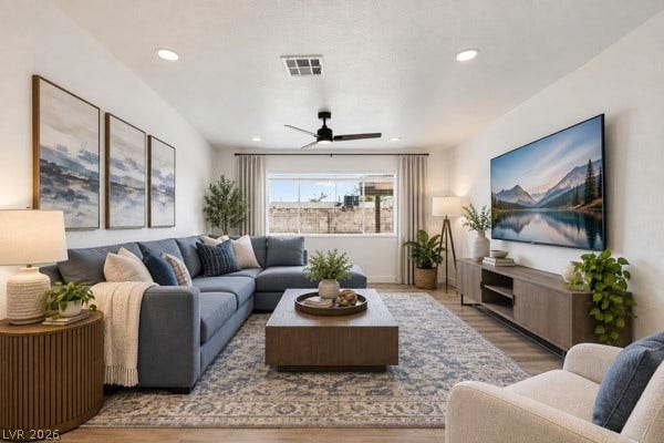 4284 Annie Oakley Drive, Las Vegas, NV 89121 Recessed lighting illuminates this inviting living space featuring high ceilings and beautiful wood-style flooring.