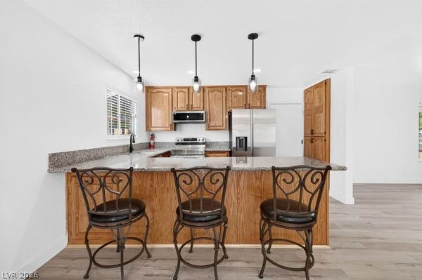 4284 Annie Oakley Drive, Las Vegas, NV 89121 Rich wood cabinetry contrasts beautifully with granite countertops in this open concept kitchen design.