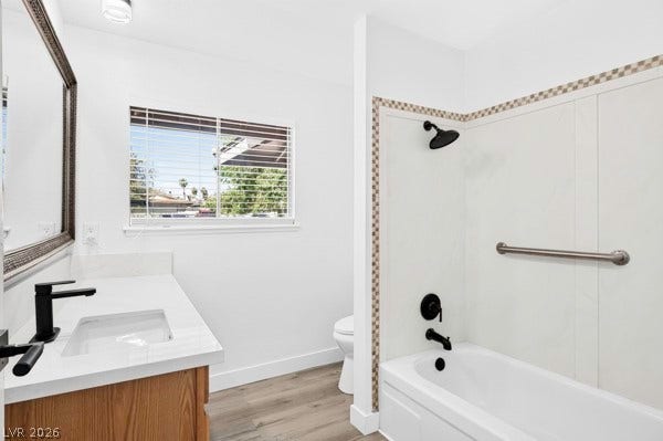 4284 Annie Oakley Drive, Las Vegas, NV 89121 A crisp white bathroom showcases a wooden vanity alongside a tub and shower combination.