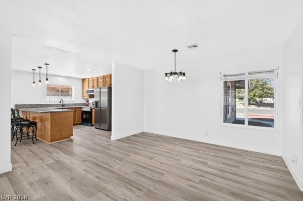 4284 Annie Oakley Drive, Las Vegas, NV 89121 Plank flooring runs throughout this open dining area connecting seamlessly to the kitchen.