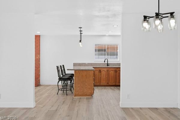 4284 Annie Oakley Drive, Las Vegas, NV 89121 Gleaming wood floors flow seamlessly into a modern kitchen complete with stone countertops.