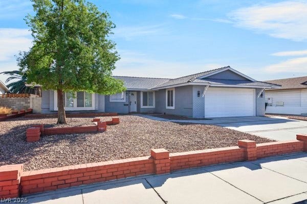 4284 Annie Oakley Drive, Las Vegas, NV 89121 A low brick retaining wall defines the neat gravel front yard of this single-story residence.