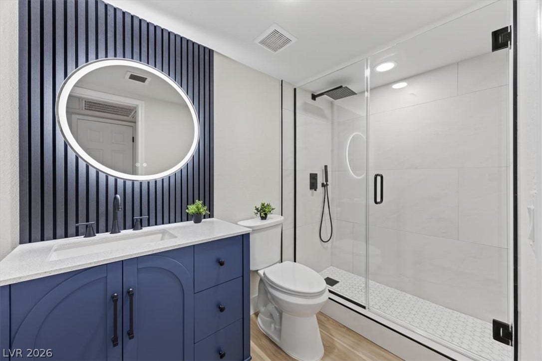 2606 S Durango Drive, #128, Las Vegas, NV 89117 A glass-enclosed shower and textured accent wall elevate this modern bathroom design.