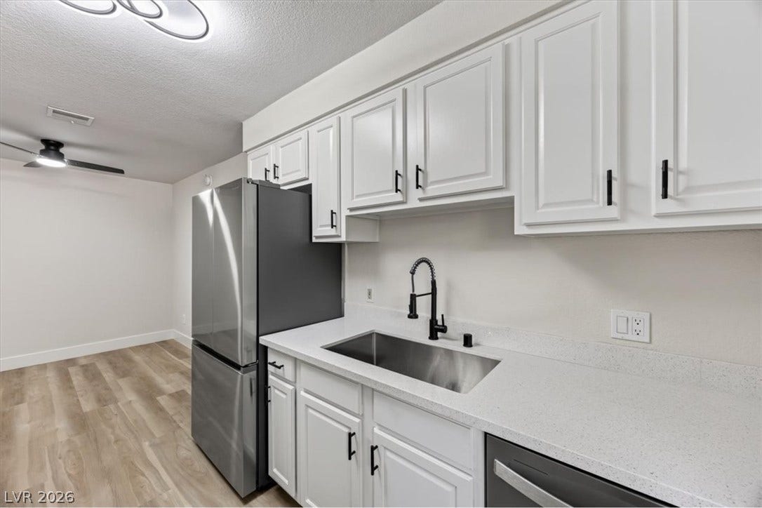 2606 S Durango Drive, #128, Las Vegas, NV 89117 Crisp white cabinetry paired with durable countertops highlights this updated culinary space.